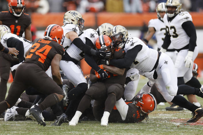 Cleveland Browns running back Kareem Hunt (27) is stopped by New Orleans Saints defensive tackle Prince Emili (57) 'during the second half of an NFL football game, Saturday, Dec. 24, 2022, in Cleveland. (AP Photo/Ron Schwane)
