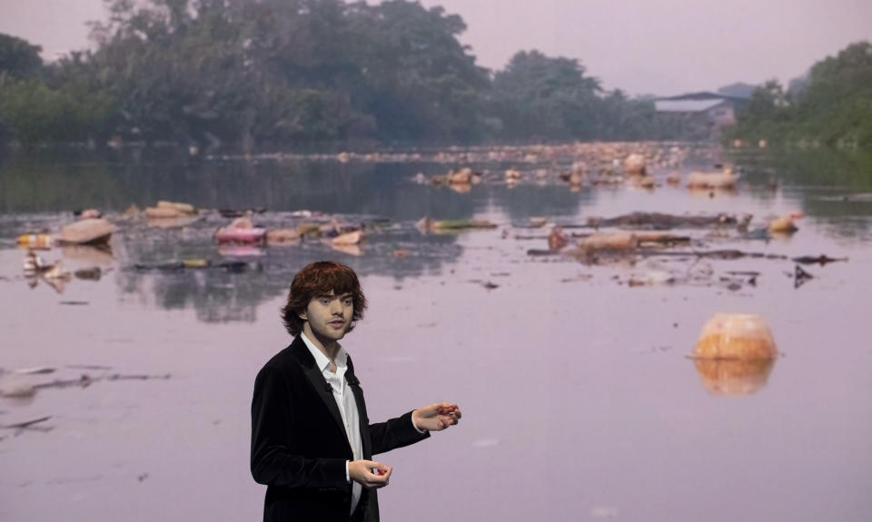 Young Dutch inventor Boyan Slat presents his plans for the Interceptor, a plastic-gathering floating device, in front of a video of a polluted river, during a presentation in Rotterdam, Netherlands, Saturday, Oct. 26, 2019. Slat is taking his effort to clean up floating plastic from the Pacific Ocean to rivers to catch garbage before it reaches the seas. (AP Photo/Peter Dejong)