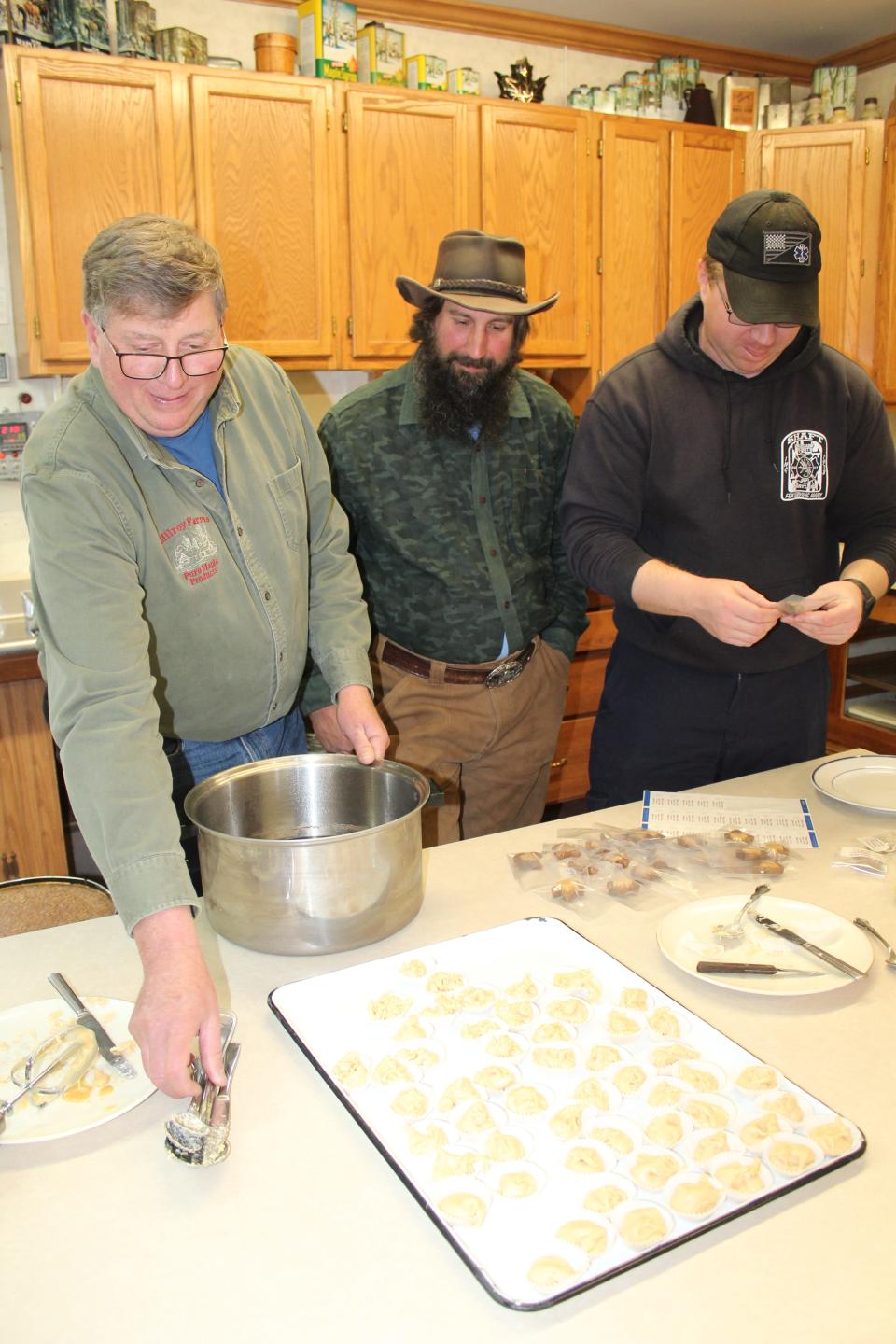 Jason Blocher (far left), owner of Milroy Farms near Salisbury, and his helpers make candies for the Maple Taste and Tour on Saturday.