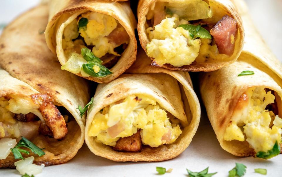 <p>Start the day with all of your favorite breakfast ingredients wrapped in a tortilla. Lay out the fixings for the taquitos and have your kids roll them into the tortillas, then you can pop them into the oven.</p> <p><a href="https://www.thedailymeal.com/best-reviews/breakfast-taquitos?referrer=yahoo&category=beauty_food&include_utm=1&utm_medium=referral&utm_source=yahoo&utm_campaign=feed" rel="nofollow noopener" target="_blank" data-ylk="slk:For the Breakfast Taquitos recipe, click here.;elm:context_link;itc:0;sec:content-canvas" class="link ">For the Breakfast Taquitos recipe, click here. </a></p>