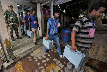 Election officials carry electronic voting machines (EVM) as they arrive to count votes in the West Bengal Assembly elections, at a counting center in Kolkata, May 19, 2016. REUTERS/Rupak De Chowdhuri