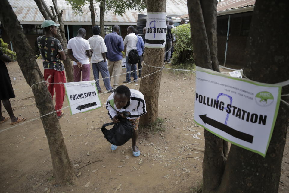 People line up to cast their vote in Kenya's general election in Eldoret, Kenya, Tuesday Aug. 9, 2022. Kenyans are voting Tuesday in an unusual presidential election, where a longtime opposition leader who is backed by the outgoing president faces the brash deputy president who styles himself as the outsider and a “hustler.” (AP Photo/Brian Inganga)