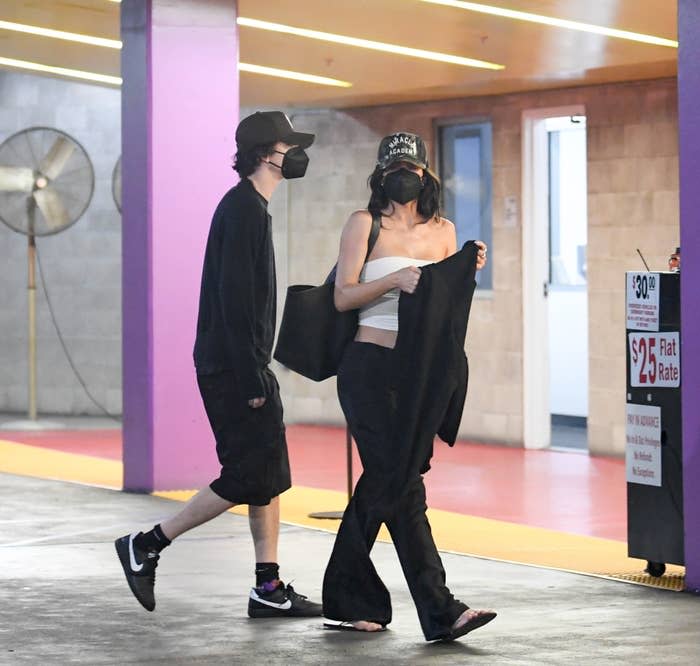 Timothée Chalamet and Kylie Jenner, both wearing masks as they walk