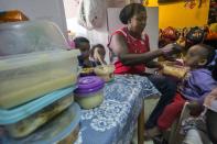 A woman feeds children from families of illegal African immigrants at a so-called day-care centre in southern Tel Aviv, on May 28, 2015