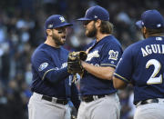 Milwaukee Brewers third baseman Mike Moustakas, left, congratulates starting pitcher Wade Miley who waits to be pulled from the mound in the sixth inning of Game 3 of a baseball National League Division Series against the Colorado Rockies, Sunday, Oct. 7, 2018, in Denver. (AP Photo/John Leyba)