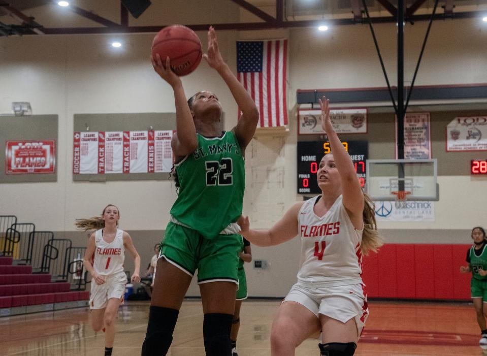 St. Mary's Jordan Lee, left, goes to the hoop over Lodi's Savannah Head during a girls varsity basketball game at Lodi on April 29, 2021.