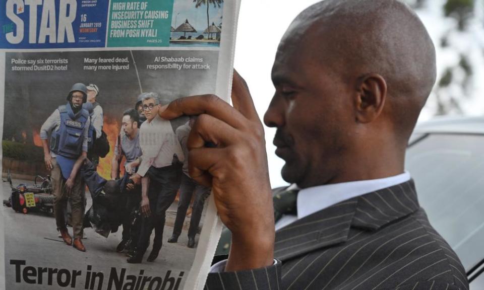 A man reads the Star newspaper during the funeral of a victim of this week’s attack on a Nairobi luxury hotel complex, at the Langata Muslim cemetery in Nairobi.