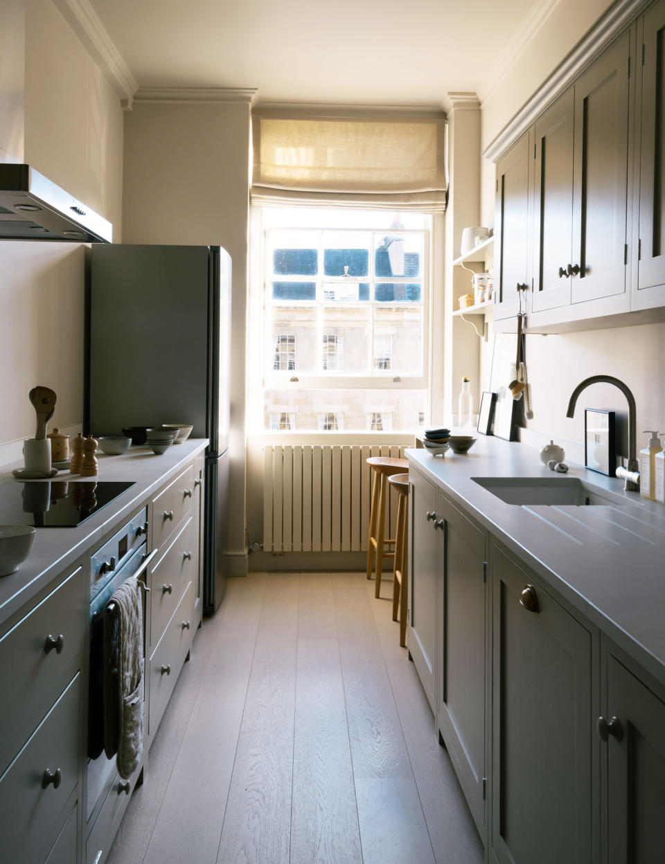 Galley kitchen with green cabinets and flooring