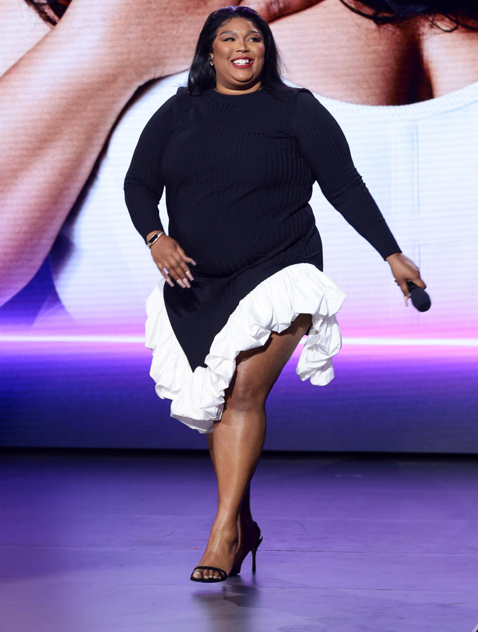 <p>Lizzo shows off her smile while speaking onstage during the Warner Bros. Discovery Upfront in N.Y.C. on May 18. </p>