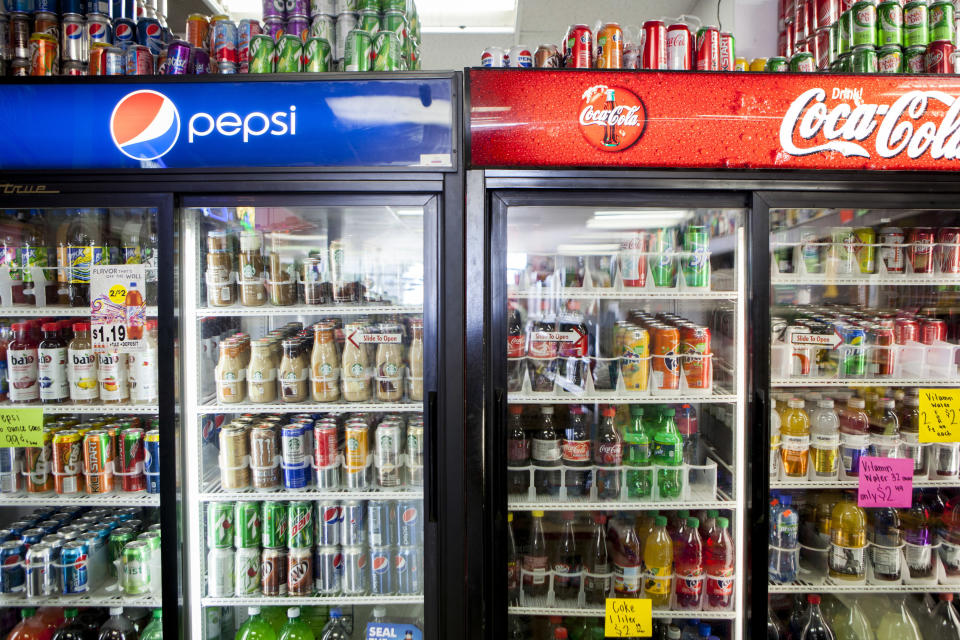 Cans of soda are displayed in a case at Kwik Stops Liquor in San Diego, California February 13, 2014. Sodas and most other sugar-sweetened drinks sold in California would be required to carry warning labels for obesity, diabetes and tooth decay under a bill introduced in Sacramento on Thursday and backed by several public health advocacy groups. REUTERS/Sam Hodgson (UNITED STATES - Tags: POLITICS FOOD HEALTH)