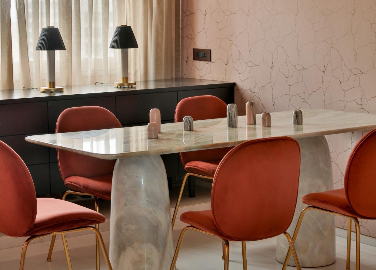  A dining room with pink wall tiles and white marble table 