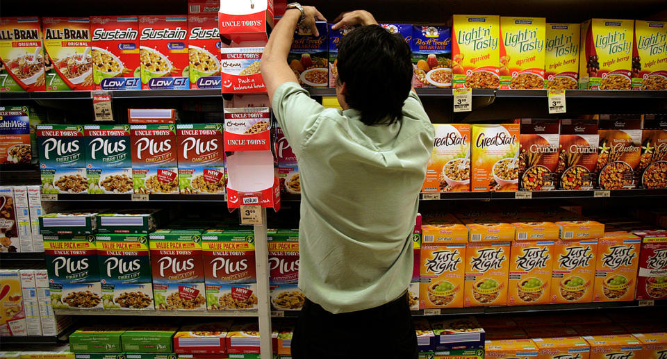 A file image of a Woolworths worker packing a shelf.