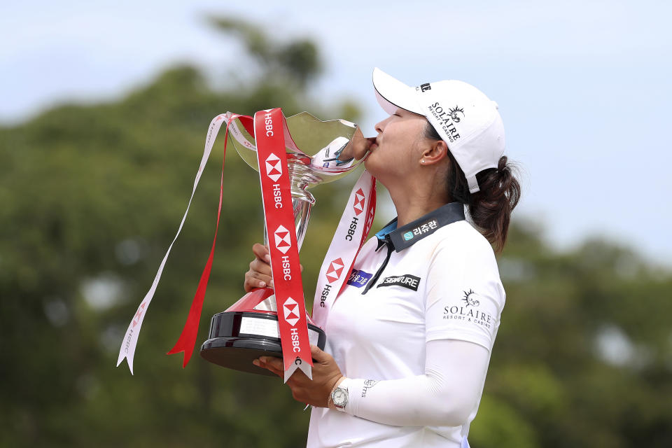 Jin Young Ko of South Korea kisses the championship trophy after winning the Women's World Championship golf tournament at Sentosa Golf Club in Singapore, Sunday, March 6, 2022. (AP Photo/Paul Miller)