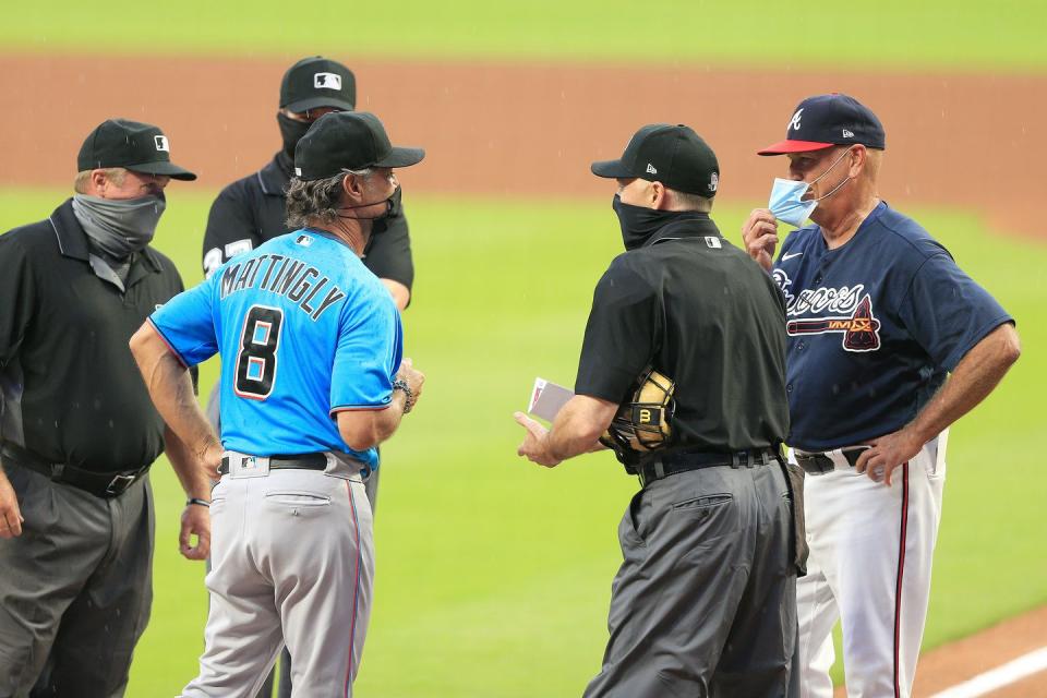 <p>Marlins manager Don Mattingly and Braves Manager Brian Snitker (r) meet with the officiating crew bedore the exhibition MLB baseball game between the Atlanta Braves and the Miami Marlins on July 21 at Truist Park in Atlanta.</p>