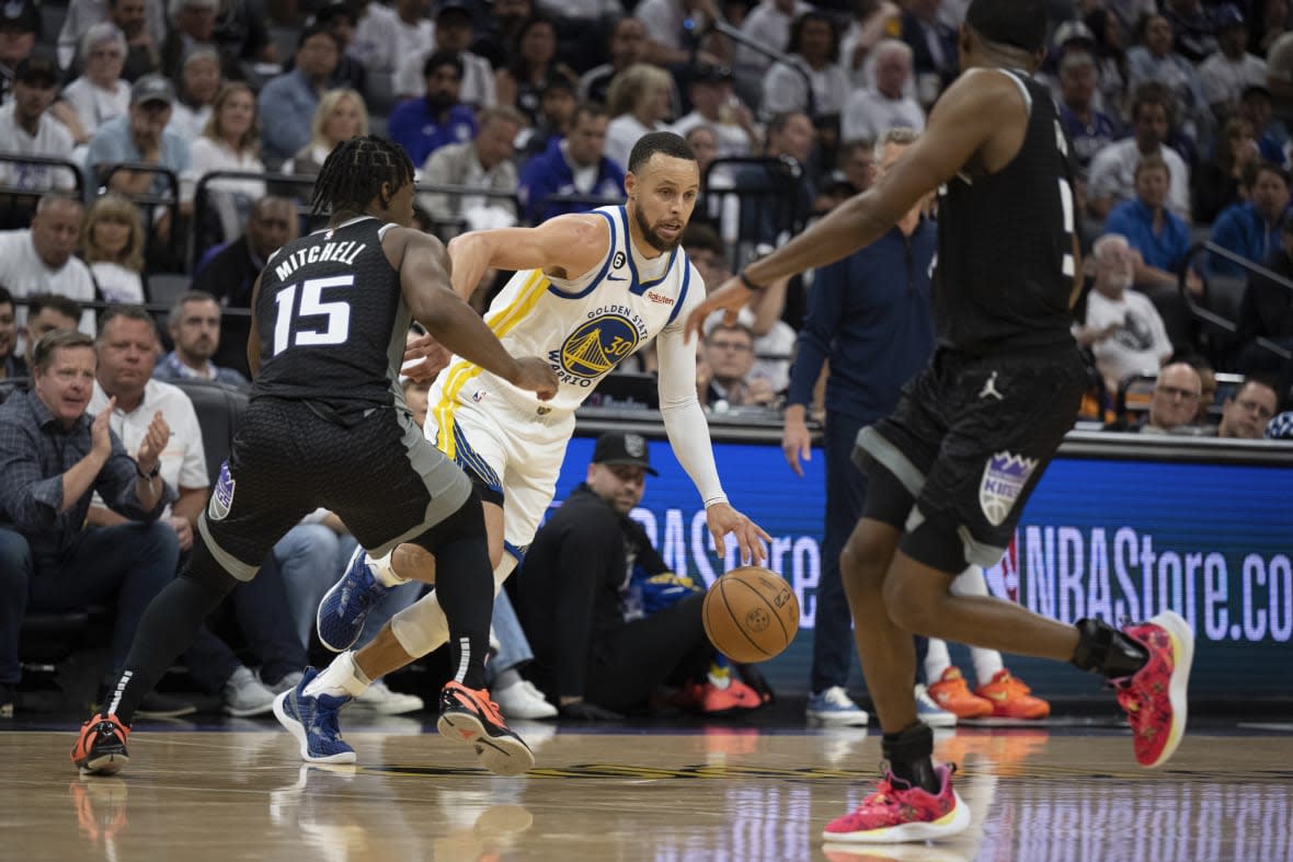 Golden State Warriors guard Stephen Curry (30) tries to dribble past Sacramento Kings guard Davion Mitchell (15) in the third quarter during Game 1 in the first round of the NBA basketball playoffs in Sacramento, Calif., Saturday, April 15, 2023. (AP Photo/José Luis Villegas)
