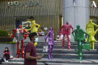 People wearing protective face masks walk along the Orchard Road shopping area in Singapore on Nov. 28, 2021. When Singapore embarked upon its strategy of “living with COVID,” backed by one of the world's leading vaccine programs, the wealthy city-state saw a spike in its rate of infections, leading many to question whether the time was right. (AP Photo/Annabelle Liang)