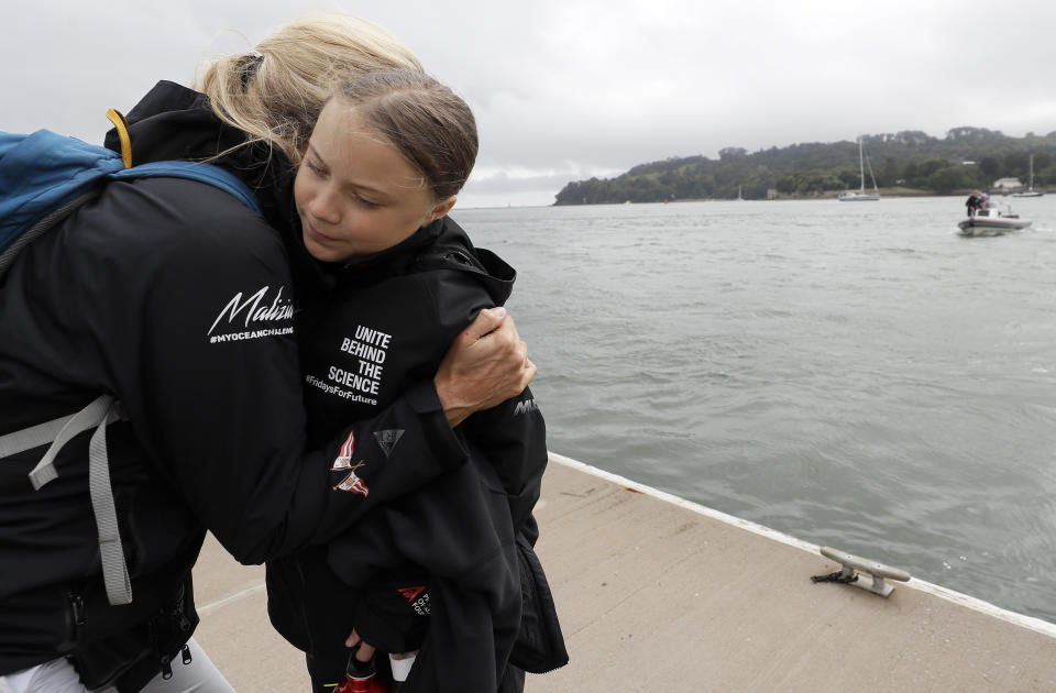 Climate change activist Greta Thunberg gets a hug before she boards the Malizia II boat in Plymouth, England, Wednesday, Aug. 14, 2019. The 16-year-old climate change activist who has inspired student protests around the world will leave Plymouth, England, bound for New York in a high-tech but low-comfort sailboat.(AP Photo/Kirsty Wigglesworth, pool)