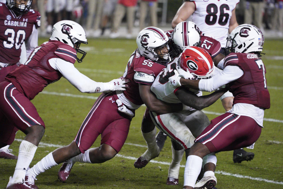 South Carolina's Gilber Edmond (55), Jammie Robinson (7) and Jaylan Foster (27) tackle Georgia running back Daijun Edwards (33) during the second half of an NCAA college football game Saturday, Nov. 28, 2020, in Columbia, S.C. Georgia won 45-16. (AP Photo/Sean Rayford)