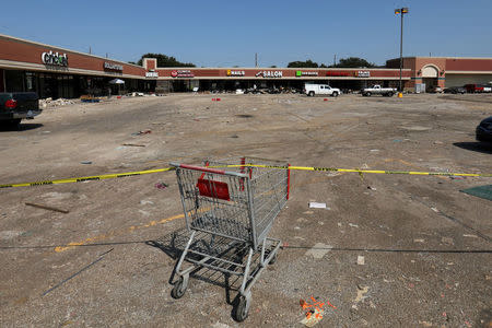A shopping cart and yellow tape are used to keep people away as the clean-up continues at a neighborhood shopping plaza following the aftermath of tropical storm Harvey in Houston, Texas, U.S., September 9, 2017. REUTERS/Mike Blake