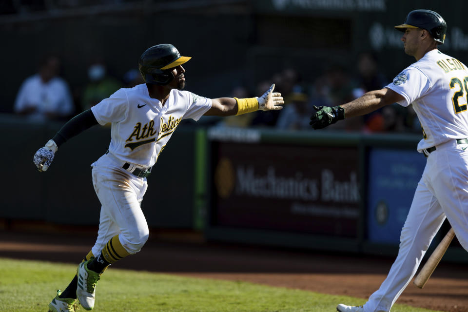 Oakland Athletics' Tony Kemp, left, celebrates with Matt Olson after scoring a run against the Houston Astros in the seventh inning of a baseball game in Oakland, Calif., Sunday, Sept. 26, 2021. (AP Photo/John Hefti)