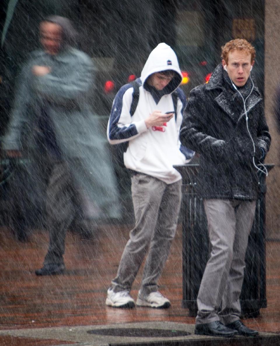 Early morning commuters wait to cross the street as snow flurries begin to fall in Washington, Tuesday, March 25, 2014. As the East Coast shivers through an unusually cold early spring, parts of the Mid-Atlantic and New England are bracing for a nor'easter that could bring additional snow. The National Weather Service says a powerful low pressure system will develop off the Mid-Atlantic coast Tuesday night. Where and how much snow falls will depend on the storm's track, according to the weather service. But, cold temperatures and windy conditions will cover the Mid-Atlantic states north into New England. (AP Photo/J. David Ake)