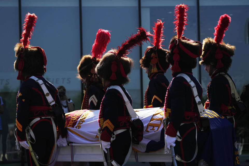 People dressed in historical costumes of the French Army at Vnukovo International Airport outside Moscow, Russia, Tuesday, July 13, 2021, carry the coffin that contains the remains of Charles-Etienne Gudin, the Napoleon-era French general who died after he was hit by a cannonball near Smolensk during the French invasion of Russia in 1812. The remains of the Napoleon-era general whose skeleton was discovered in July 2019 by a team of French and Russian archaeologists under a dance floor in Smolensk, Russia, were repatriated to France Tuesday. (AP Photo/Pavel Golovkin)