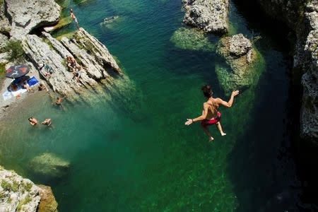 A boy jumps into the Cijevna river to cool off near Tuzi as a heatwave hits Montenegro, August 4, 2017. REUTERS/Stevo Vasiljevic