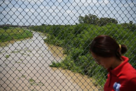 A pedestrian walks above the Rio Grande on the Mexican side of the Brownsville-Matamoros International Bridge