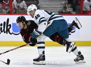 Ottawa Senators right wing Alex DeBrincat (12) gets becomes entangled with San Jose Sharks center Tomas Hertl (48) during the second period of an NHL hockey game Saturday, Dec. 3, 2022, in Ottawa, Ontario. (Justin Tang/The Canadian Press via AP)