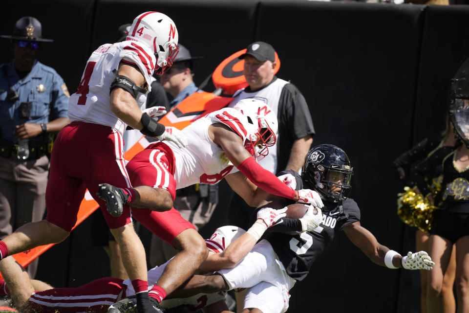 Colorado wide receiver Jimmy Horn Jr., right, is pushed out of bounds Nebraska safety Jahquez Robinson, center, and linebacker Luke Reimer after catching a pass by in the second half of an NCAA college football game Saturday, Sept. 9, 2023, in Boulder, Colo. (AP Photo/David Zalubowski)