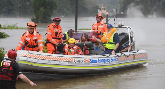 A family of four, including two young children, had their rescue boat capsize during their evacuation from a flooded property at Upper Colo. Source: AAP
