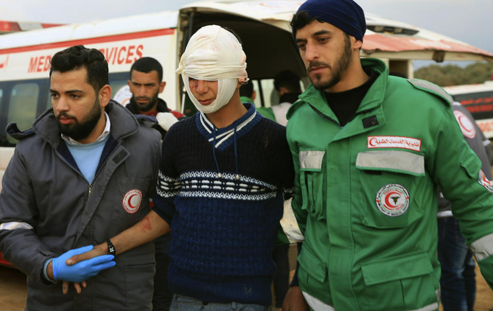 Medics help a wounded youth protestor to the field clinic tent after he was shot at, during a protest near the fence of the Gaza Strip border with Israel, near Beit Lahiya, northern Gaza Strip, Tuesday, Feb. 19, 2019. (AP Photo/Adel Hana)