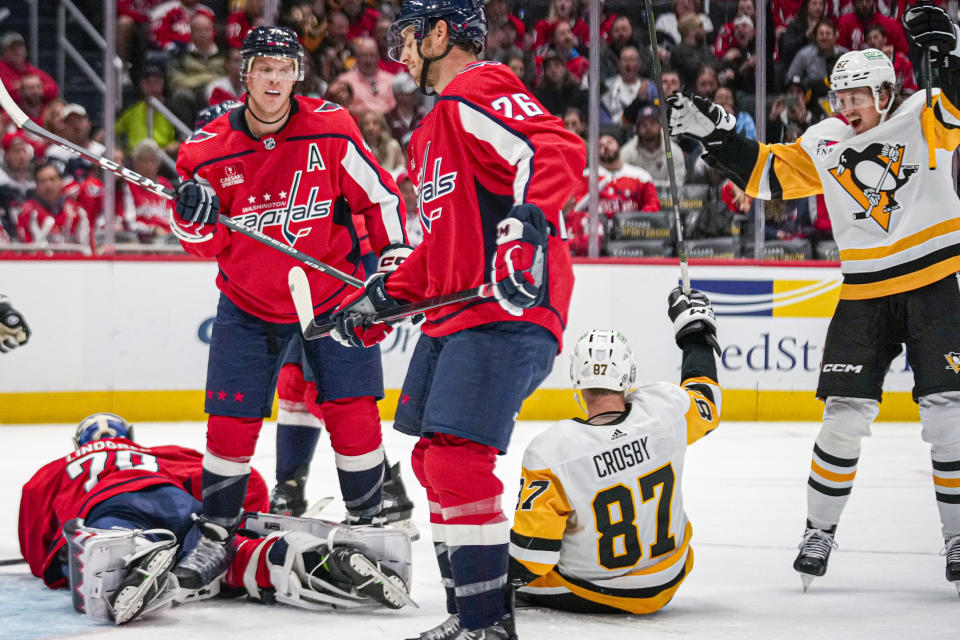 Pittsburgh Penguins right wing Rickard Rakell (67) reacts as Penguins center Sidney Crosby (87) scores in the second period of an opening night NHL hockey game against the Washington Capitals, Friday, Oct. 13, 2023, in Washington. (AP Photo/Andrew Harnik)