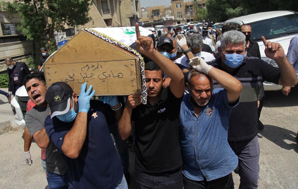 Mourners carry the flag-draped coffin of Hisham al-Hashimi during his funeral, in the Zeyouneh area of Baghdad, Iraq, Tuesday, July, 7, 2020. Al-Hashimi, an Iraqi analyst who was a leading expert on the Islamic State and other armed groups, was shot dead in Baghdad on Monday. (AP Photo/Khalid Mohammed)