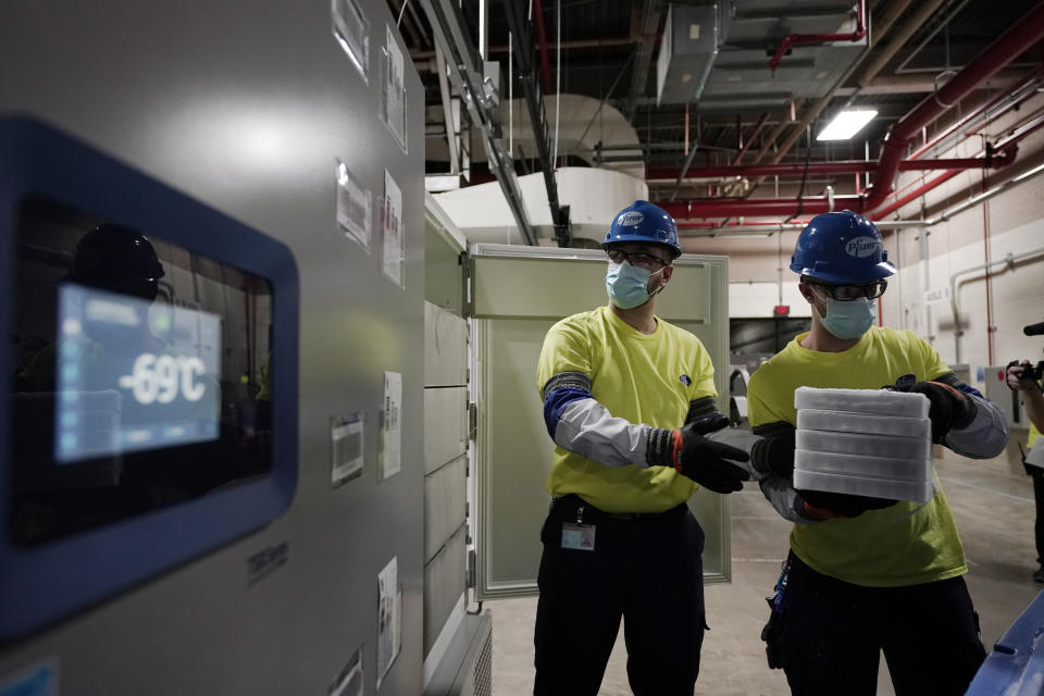 Workers handle boxes containing the Pfizer-BioNTech COVID-19 vaccine as they are prepared to be shipped at the Pfizer Global Supply Kalamazoo manufacturing plant in Portage, Mich., Sunday, Dec. 13, 2020. (AP Photo/Morry Gash, Pool)