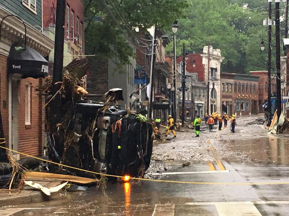 <p>Rescue personnel walk along Ellicott City’s Main Street. (Photo: Libby Solomon, Baltimore Sun via AP) </p>