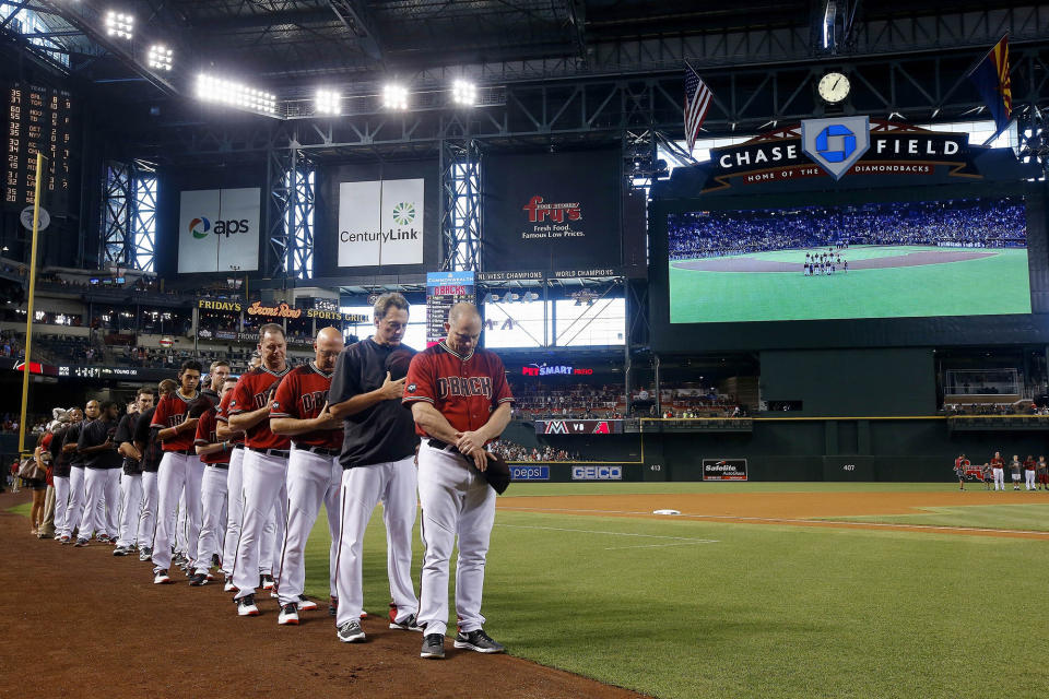 <p>Arizona Diamondbacks manager Chip Hale, right, hitting coach Dave Magadan, second from right, pitching coach Mike Butcher, third from right, and bench coach Glenn Sherlock, fourth from right, join other Diamondbacks coaches and players for a moment of silence for the Orlando, Fla., mass shooting victims prior to a baseball game against the Miami Marlins, June 12, 2016, in Phoenix. (AP Photo/Ross D. Franklin) </p>