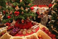 BERLIN, GERMANY - NOVEMBER 26: Visitors look at Christmas decorations for sale at the Kaethe Wohlfahrt stand at the annual Christmas market at Gendarmenmarkt on its opening day on November 26, 2012 in Berlin, Germany. Christmas markets, with their stalls selling mulled wine, Christmas tree decorations and other delights, are an integral part of German Christmas tradition, and many of them opened across Germany today. (Photo by Sean Gallup/Getty Images)