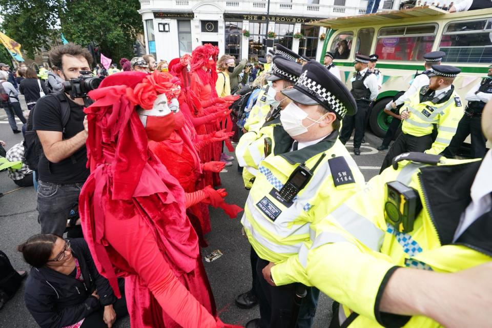 Police and demonstrators with a bus parked on London Bridge in central London during a protest by members of Extinction Rebellion (PA Wire)