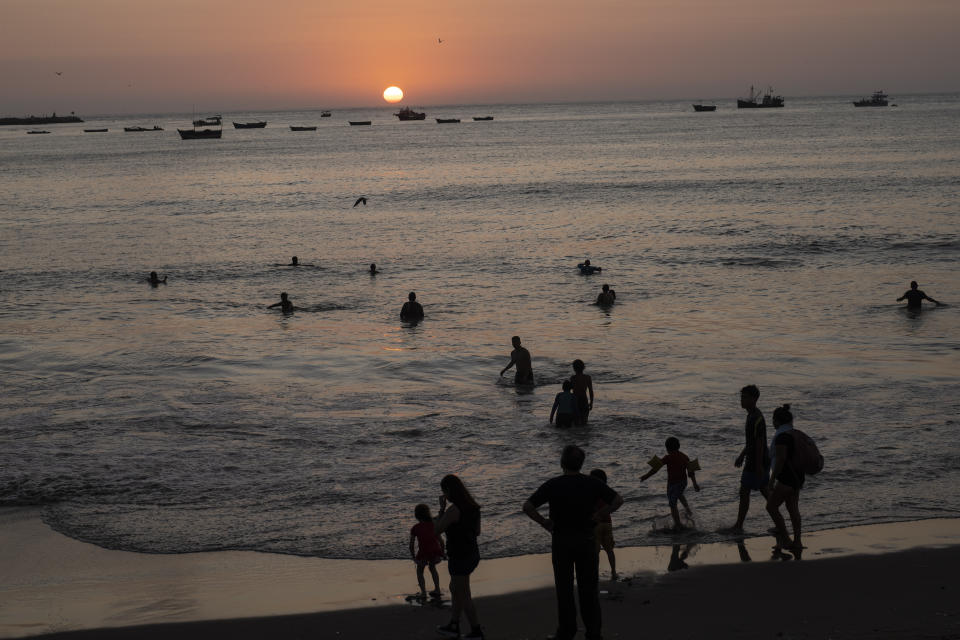 FILE - People bathe in the Pacific Ocean at Agua Dulce beach at sunset in Lima, Peru, Feb. 8, 2023. The world's oceans have suddenly spiked much hotter and well above record levels, with scientists trying to figure out what it means and whether it forecasts a surge in atmospheric warming. (AP Photo/Rodrigo Abd, File)