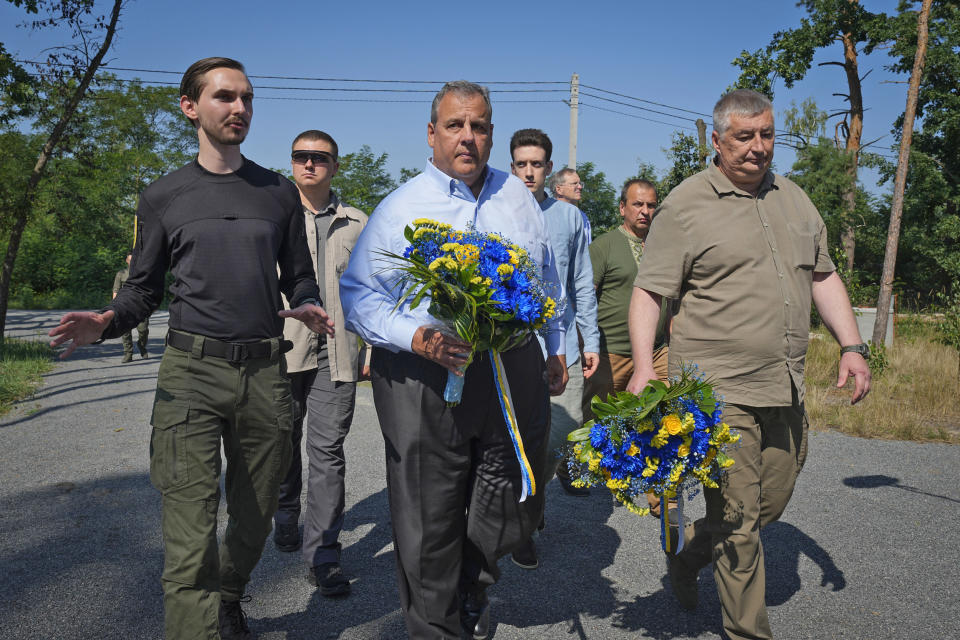 Former New Jersey Gov. Chris Christie, center, participates in a flower laying ceremony as he visits a former defense line in Moshchun, Ukraine, on the outskirts of Kyiv, Friday, Aug. 4, 2023.  (Efrem Lukatsky / AP)