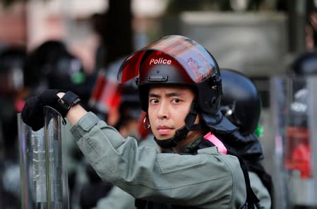 A police officer looks on as he blocks the road as anti-government protesters gather in Tin Shui Wai in Hong Kong