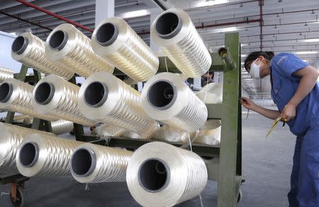 An employee works at a production line of a textile factory in Lianyungang, Jiangsu province, August 1, 2016. China Daily/via REUTERS