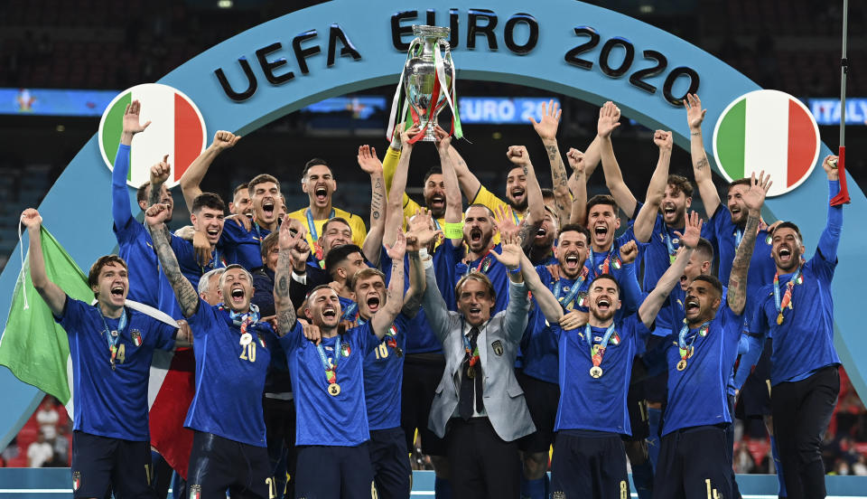 Italy's team celebrates with the trophy on the podium after winning the Euro 2020 soccer championship final between England and Italy at Wembley stadium in London, Sunday, July 11, 2021. (Michael Regan/Pool via AP)