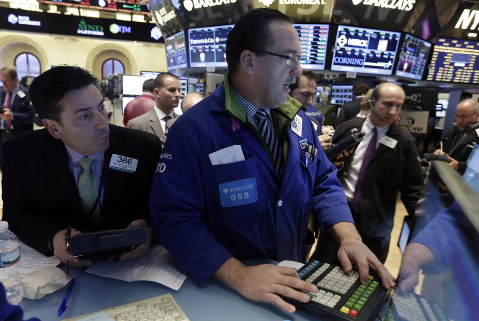 Trader Steven Grasso, left, looks over the shoulder of specialist Anthony Matesic on the floor of the New York Stock Exchange Tuesday, Feb. 4, 2014. Stocks are mixed on Wall Street after suffering big losses the day before. (AP Photo/Richard Drew)