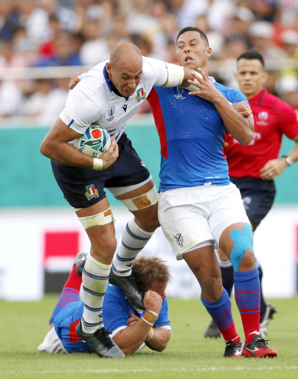 Italy’s Sergio Parisse, left, carries the ball while being tackled by Namibia during the Rugby World Cup Pool B game between Italy and Namibia in Osaka, western Japan, Sunday, Sept. 22, 2019. (Ichiro Sakano/Kyodo News via AP)