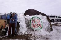 Benji Buffalo (R) greets a friend to his campsite inside of the Oceti Sakowin camp as "water protectors" continue to demonstrate against plans to pass the Dakota Access pipeline near the Standing Rock Indian Reservation, near Cannon Ball, North Dakota, U.S., December 2, 2016. REUTERS/Lucas Jackson