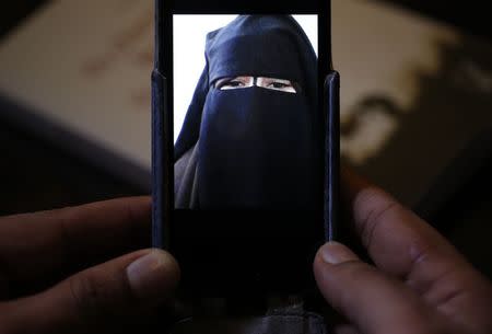 Foad, the brother of 15 year-old Nora who left her home in Avignon for Syria nine months ago, shows a portrait he took last September on his cell phone as he attends an interview with Reuters in Paris, October 6, 2014. REUTERS/Christian Hartmann