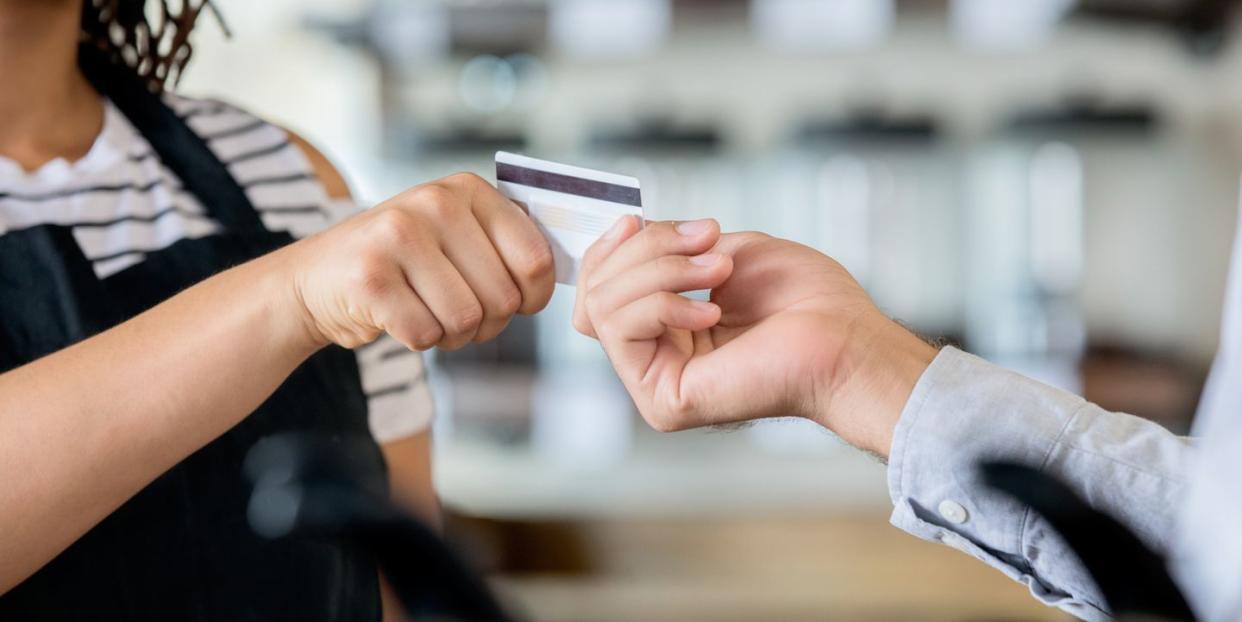 customer using card to pay barista for coffee