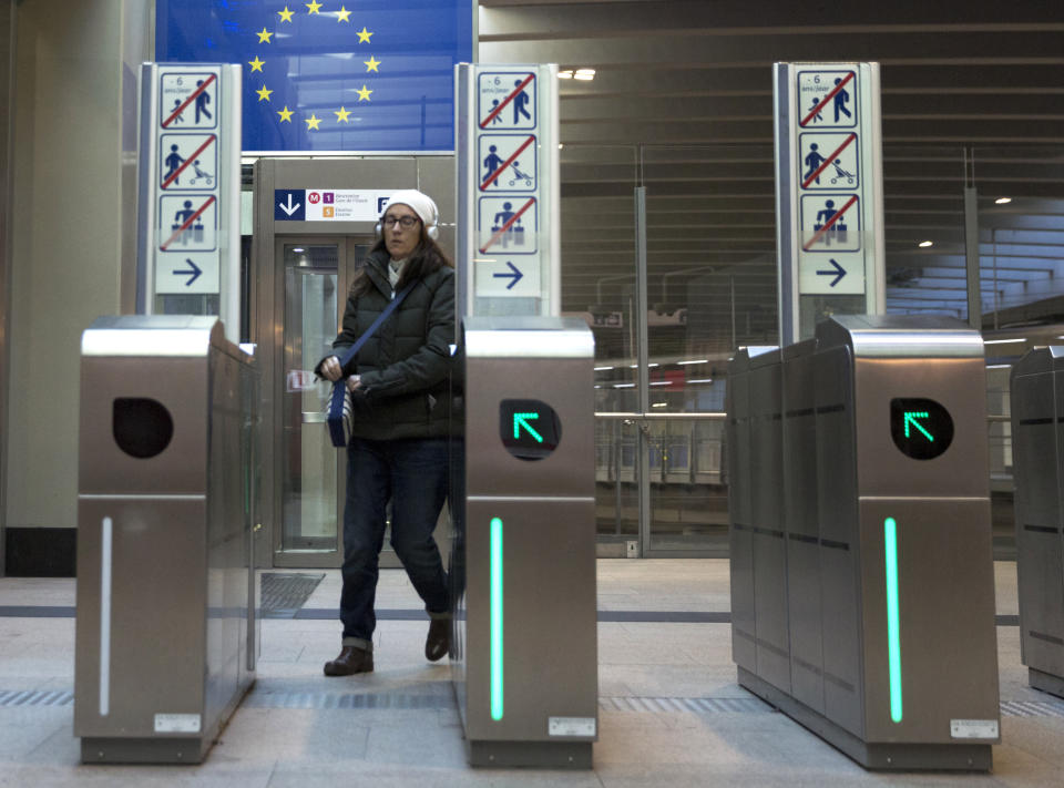 A woman exits the metro station under a symbol of the EU in the EU quarter of Brussels, Tuesday, March 19, 2019. Germany's European affairs minister Michael Roth says Brexit is not a game and that the EU is worn out by two years of tortuous and interminable negotiations over Britain's departure from the bloc. (AP Photo/Virginia Mayo)